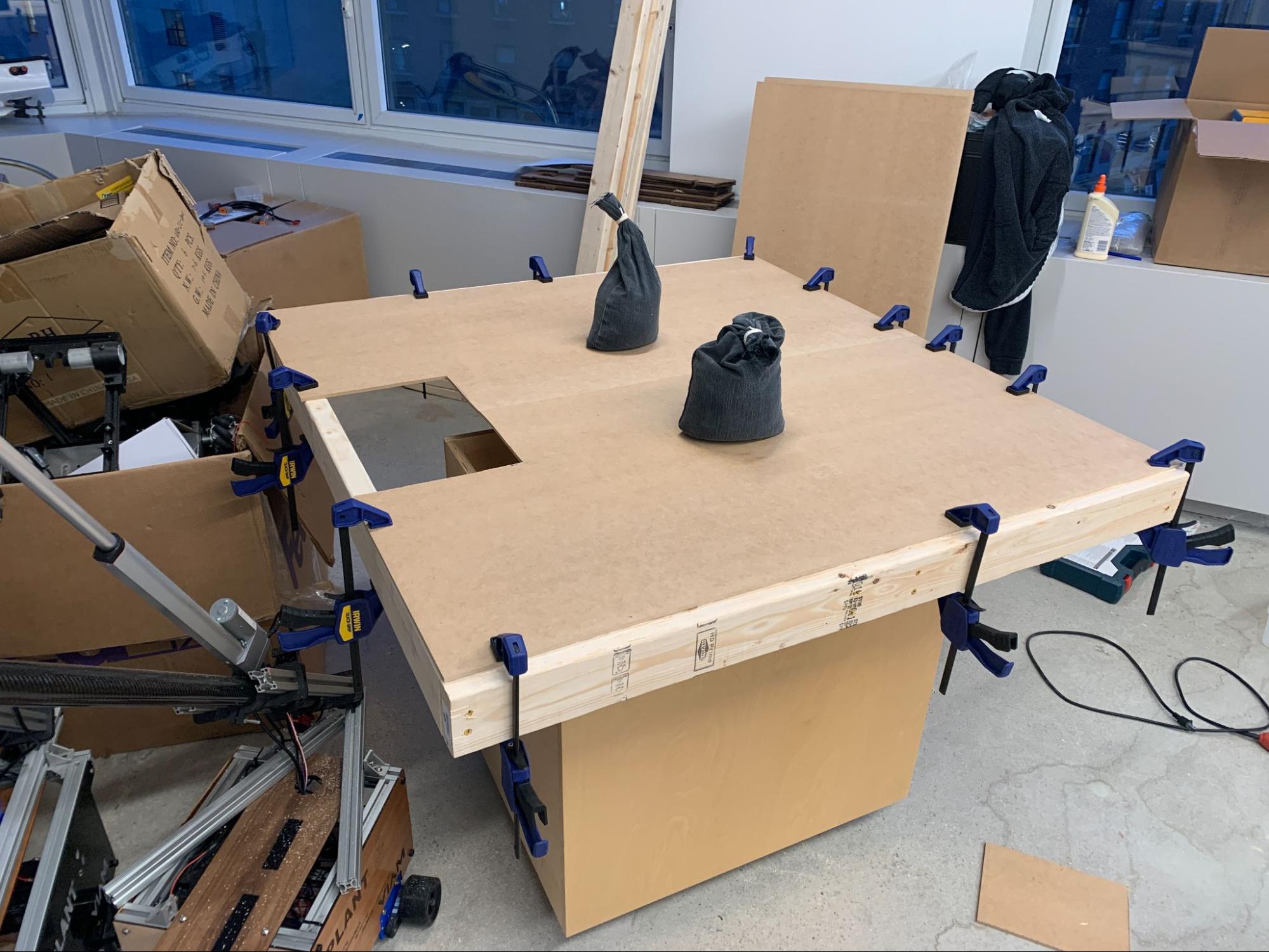 Wooden table top glued and secured with clamps